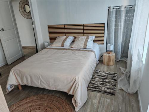 a bedroom with a large bed with white sheets and pillows at Cocooning in Cerences