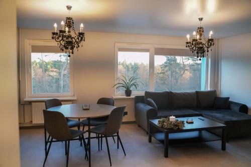 een woonkamer met een bank en een tafel bij Jumara Apartment in Valmiera