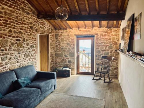 un soggiorno con un divano e un muro di mattoni di Casa Betta - A 700 Year Old Tuscan Gem a Chiusdino