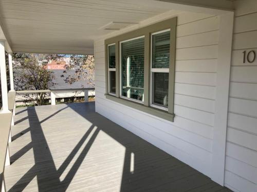 eine Veranda eines weißen Hauses mit einem Fenster in der Unterkunft The Jackson House in Jackson