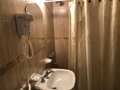 a bathroom with a sink and a phone on the wall at Calafquén in San Antonio Este