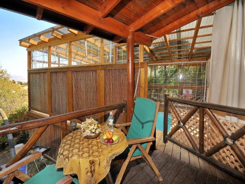 a patio with a table and chairs on a deck at Rosh Pinat Noy in Rosh Pinna