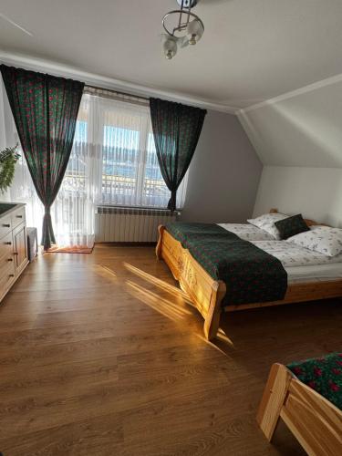 a bedroom with a bed and a large window at Spokój u Zosi in Stare Bystre
