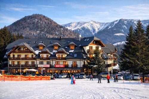 un rifugio sciistico in montagna con persone sulla neve di Kamzík Ski Apartment Donovaly - Apartmán 64 hneď pri zjazdovke a Donovaly