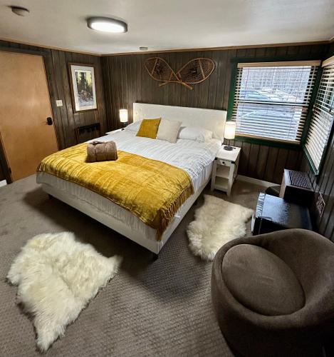a bedroom with a bed and a chair and rugs at Silver Fork Lodge & Restaurant in Brighton