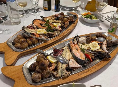 een tafel met twee dienbladen eten erop bij Casa cidade e piscina in Coimbra