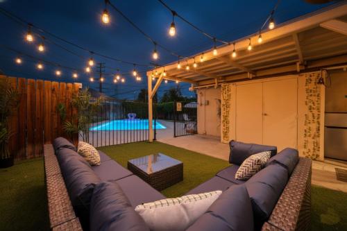 a patio with a couch and a table and a pool at Chic Boho Retreat - Pool, Spa, Patio, Mini Golf & Arcade, Mins from Universal Studios! in Los Angeles
