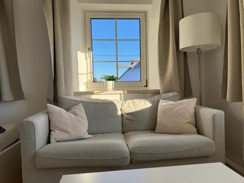 a living room with a couch and a window at Yellow House Apartments - Top 3 in Steyr