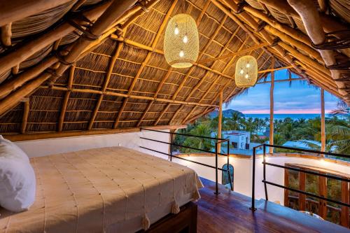 una camera con un letto in una capanna di paglia di Amari Sayulita Boutique Hotel a Sayulita