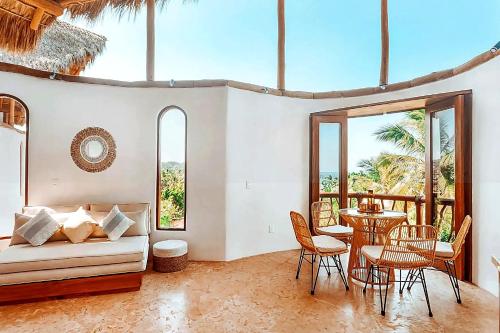 un soggiorno con un divano, un tavolo e delle sedie di Amari Sayulita Boutique Hotel a Sayulita