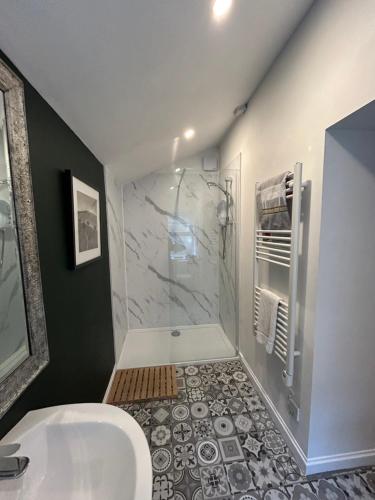 a bathroom with a shower and a white sink at Fox Cottage in Moffat