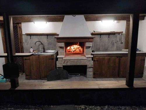 a kitchen with an oven with a fire in it at Пътепис in Bratsigovo