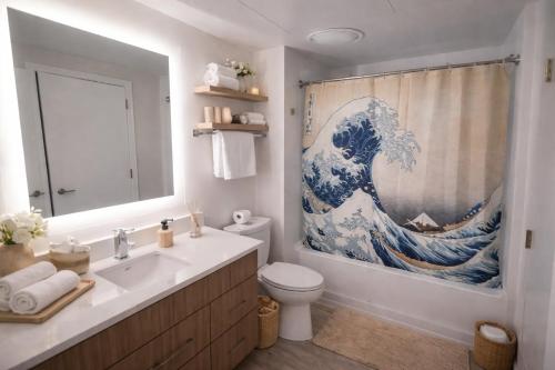 a bathroom with a sink and a large wave shower curtain at The Casa - U Street in Washington, D.C.