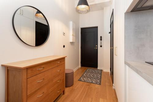 a bathroom with a wooden dresser and a mirror at Cozy Duo Loft Studio in Tartu