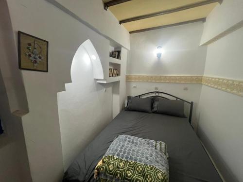 a small bedroom with a bed in the corner at Riad Ingbiwn N'Tiznit in Tiznit