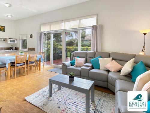 a living room with a couch and a table at Phillip Island Villa - Phillip Island Resort in Cowes