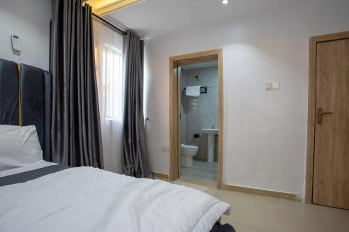 a bedroom with a bed and a bathroom with a toilet at Love Square Platinum in Ilora