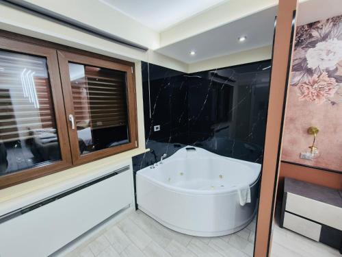 bagno con vasca bianca e finestra di B&B Golden House & spa a Rose