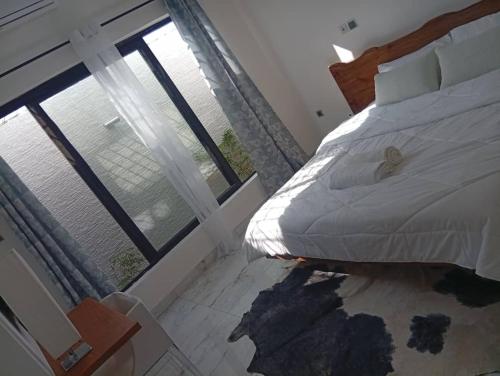 una camera da letto con un letto e una grande finestra di Villa Blanche a Cotonou