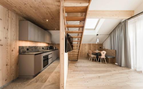 een keuken en eetkamer met houten wanden en een trap bij Wieserhof Family Farm in Maranza