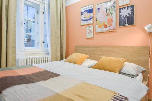 a bedroom with a bed with orange walls and a window at Olomouc Central Apartment in Olomouc