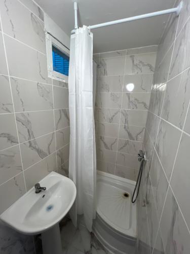 une salle de bain blanche avec lavabo et douche dans l'établissement Casa Bianca, à Marseille