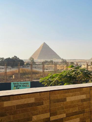 a sign with the pyramids in the background at Farida Pyramid Boutique Hotel in Cairo
