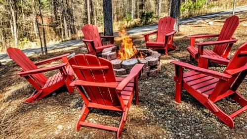 a group of red chairs around a fire pit at Serene mountain cabin with hot tub and 2 ensuites in Stephens Gap