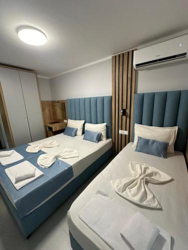 two beds sitting next to each other in a room at Hotel SPICH - Pearl Beach Resort in Čanj