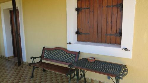 a bench in a room with a window and a table at Villa Medusa in Hersonissos