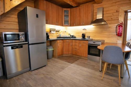 una cucina con frigorifero in acciaio inox e tavolo di Chata pri Kaštieli Longevity Nature Retreat a Necpaly