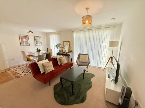 a living room with a red couch and a tv at Issara Apartments 49 - Great location & Private Parking in Portsmouth