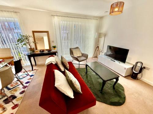 a living room with a red couch and a television at Issara Apartments 49 - Great location & Private Parking in Portsmouth