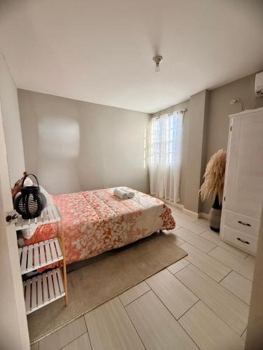 a bedroom with a bed and a tiled floor at A Hidden Gem 2BR apartment in Couva