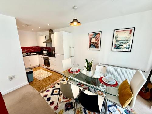a kitchen and dining room with a glass table and chairs at Issara Apartments 49 - Great location & Private Parking in Portsmouth