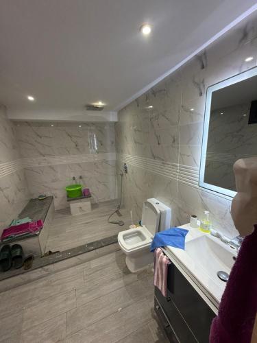 a bathroom with a toilet and a sink and a mirror at Saad's villa in Mohammedia