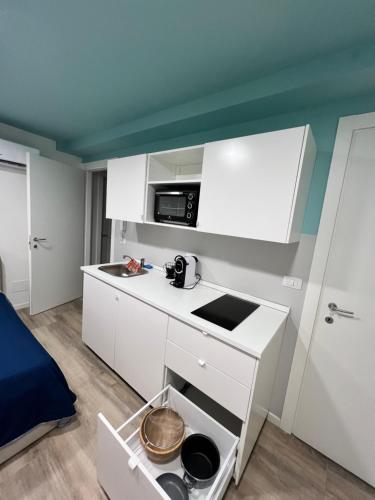 een kleine keuken met witte kasten en een magnetron bij Residence della Accademia in Modena