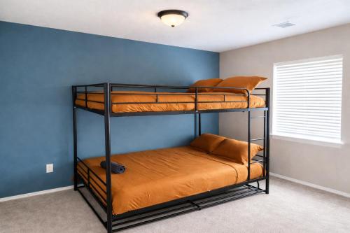 2 stapelbedden in een kamer met een blauwe muur bij Crew Stay Sleeps 16 Work, Cook, Play & Relax in Navo