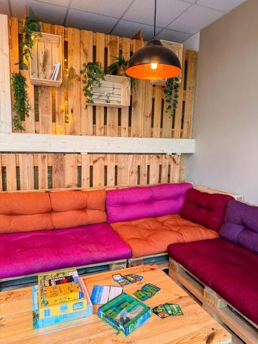 un soggiorno con divani viola e rosa e un tavolo di Urban Capsule a Dresda