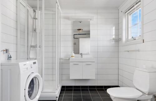 een witte badkamer met een toilet en een wastafel bij Ytterviks Rorbu Lofoten Welcome 欢迎 in Stamsund