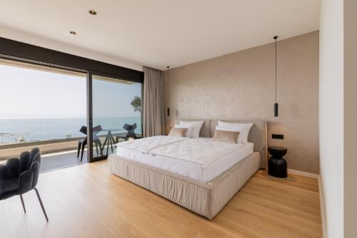 ein Schlafzimmer mit einem großen Bett und einem großen Fenster in der Unterkunft Villa Reina in Makarska