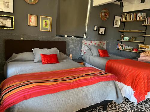 two beds in a room with red and grey at Cajanegra in El Cerrillo