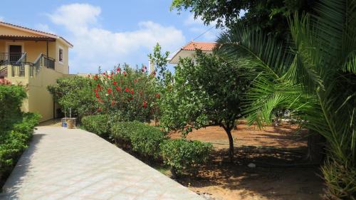 a walkway in front of a house with trees and bushes at Villa Medusa in Hersonissos