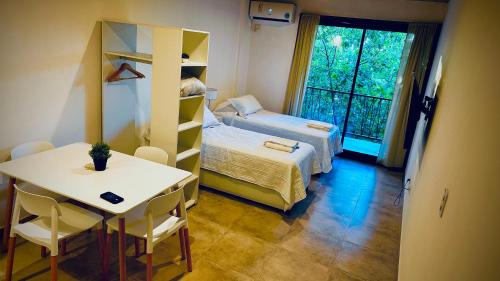 a small room with a bed and a desk and a table at Studio 44 Escobar in Belén de Escobar