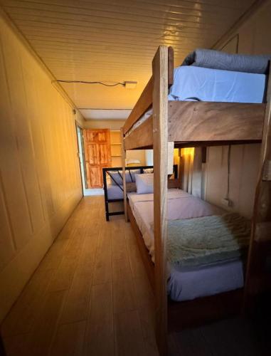 een hal met 2 stapelbedden in een kamer bij Cabina Entre Playas in Huacas