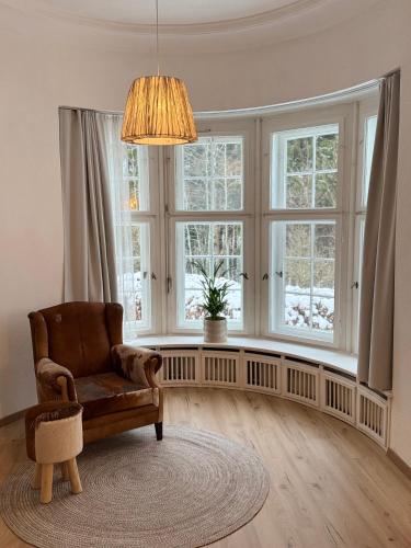a living room with a chair and windows at Waldquartier Erzgebirge in Thermalbad Wiesenbad