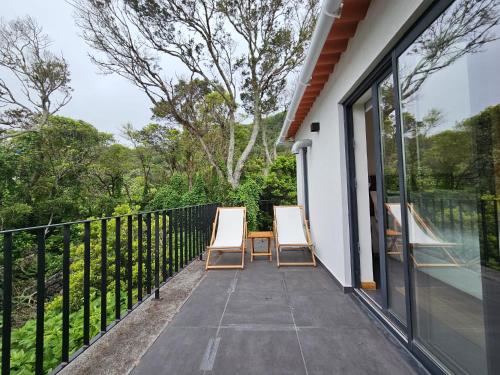 two chairs on the balcony of a house at Blue Horizon Apartments in Varadouro