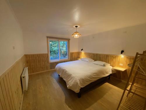 una camera da letto con un letto e una finestra di Hotel Río Puelo a Puelo