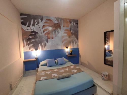 een slaapkamer met twee bedden en een schilderij aan de muur bij La Casa de Adry in Cali