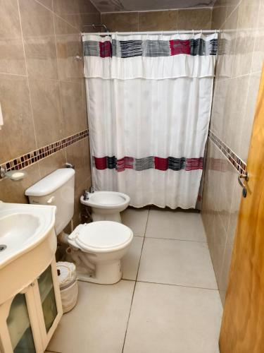 a bathroom with a toilet and a shower curtain at DUPLEX Stadium in Tanti